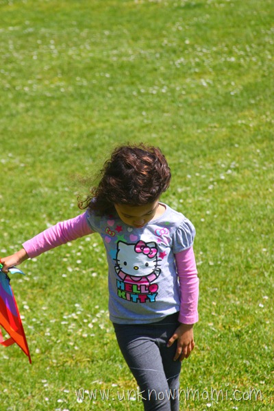 Little girl carrying a kite