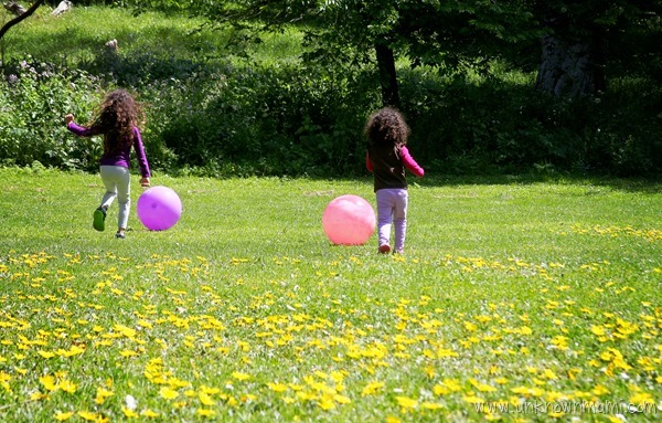 Two little girls playing ball in the park