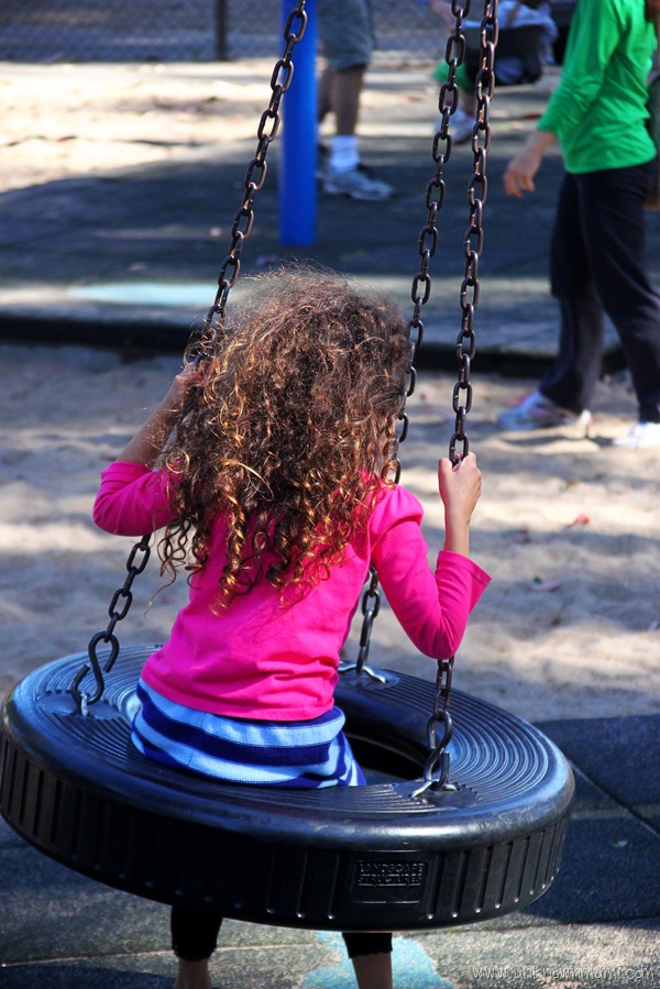 Little girl on tire swing