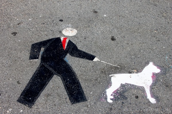 Man in suit walking dog leash sign