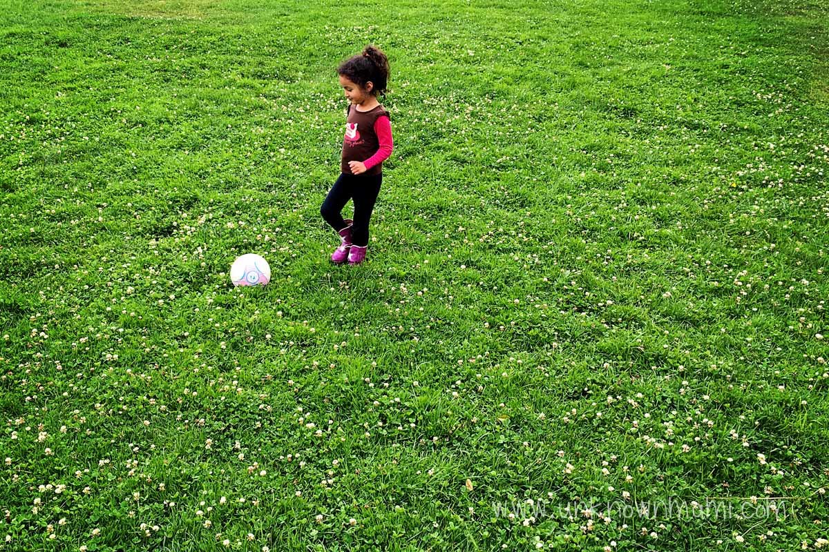 Little girl playing with soccer ball