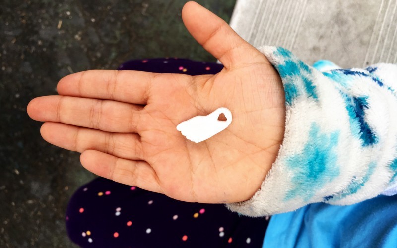 Child's hand with foot charm