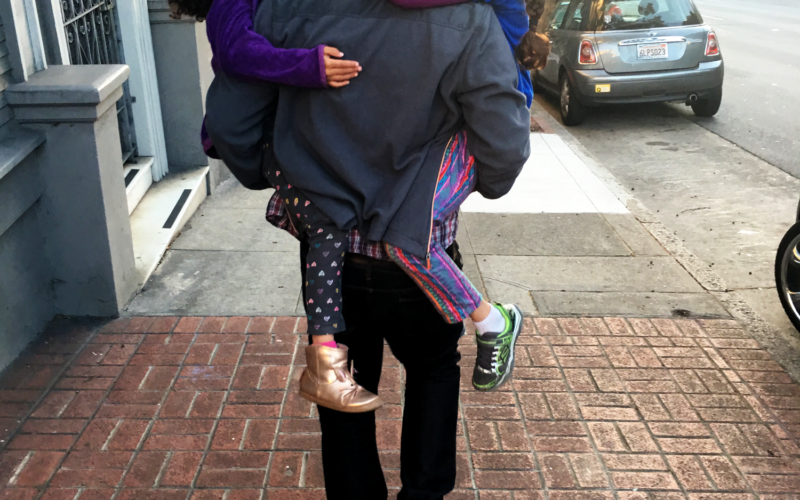 Father carrying daughters