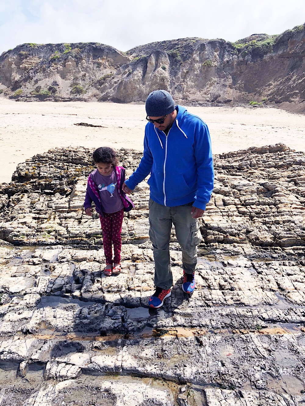 Father and daughter on rock