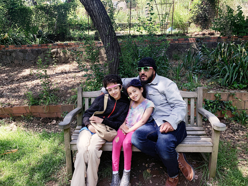 Father and daughters on park benches