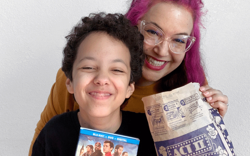 Mother and daughter holding ACT II popcorn and movie DVD